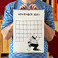Chico con camiseta a rayas azules sosteniendo el calendario 2027 ilustrado por Helen B abierto por el mes de noviembre, con ilustración de un chico a cuatro patas con un perro encima y un gato encima del perro