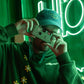Chico con sudadera y gorra verdes haciendo una foto con cámara desechable