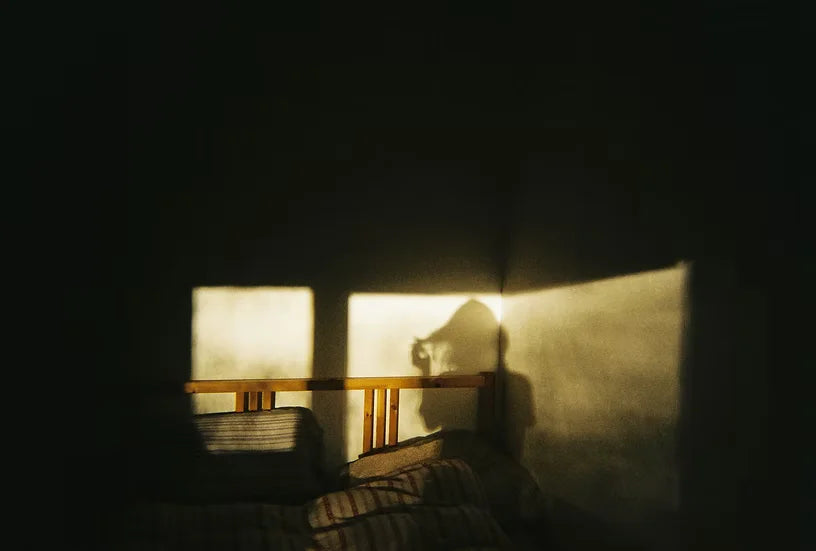 Fotografía analógica de la sombra de una chica en una pared de una habitación tomada con la cámara Miss Me? de Ninm Lab