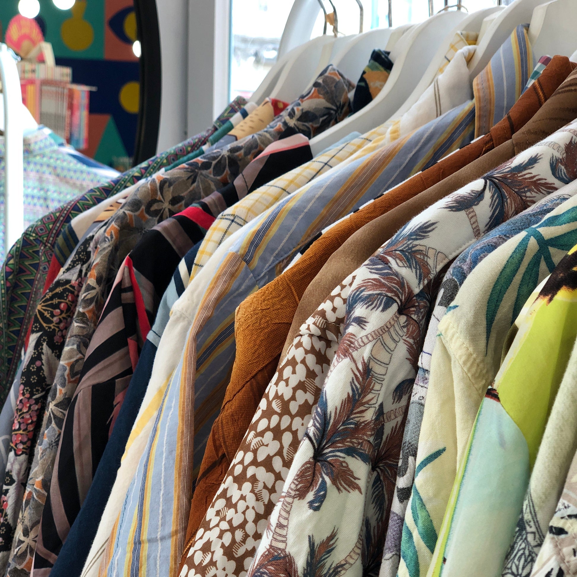 Camisas vintage con estampados variados puestas en perchas y vistas de lado