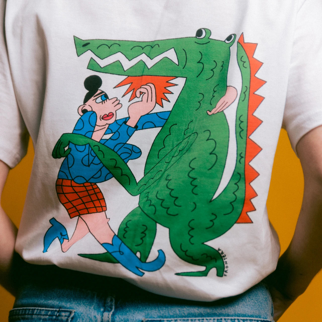 detalle de la camiseta fight the patriarchy donde se ve a una mujer peleándose con un cocodrilo