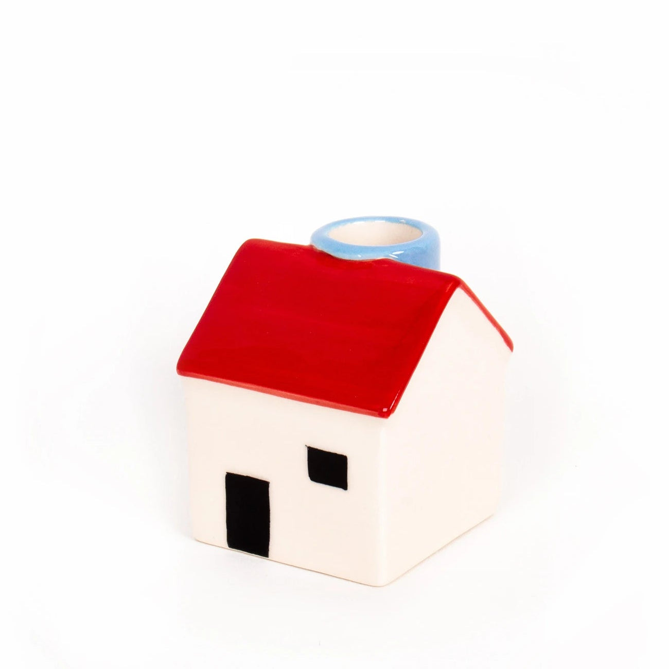 portavelas de cerámica en forma de casita blanca con la ventana y la puerta negras, el tejado rojo y una chimenea en azul, donde poner la vela