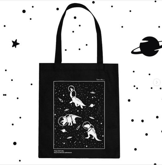 detalle de la tote bag de dinosaurios de Laura Ortiz con dibujo en blanco sobre fondo negro