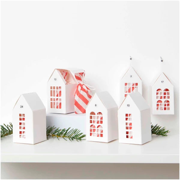 Seis casitas de cartón blanco llenas con regalitos envueltos en papel rojo y blanco