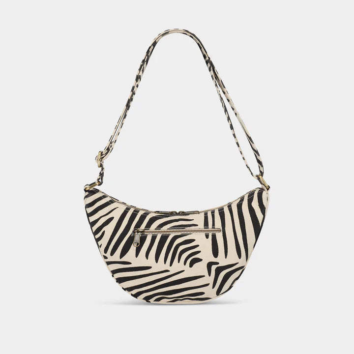 parte trasera del bolso Andrea de la marca Hindbag en estampado cebra y fondo crema, con un bolsillo