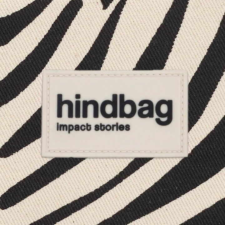 logo de hindbag sobre estampado cebra y color crema de fondo