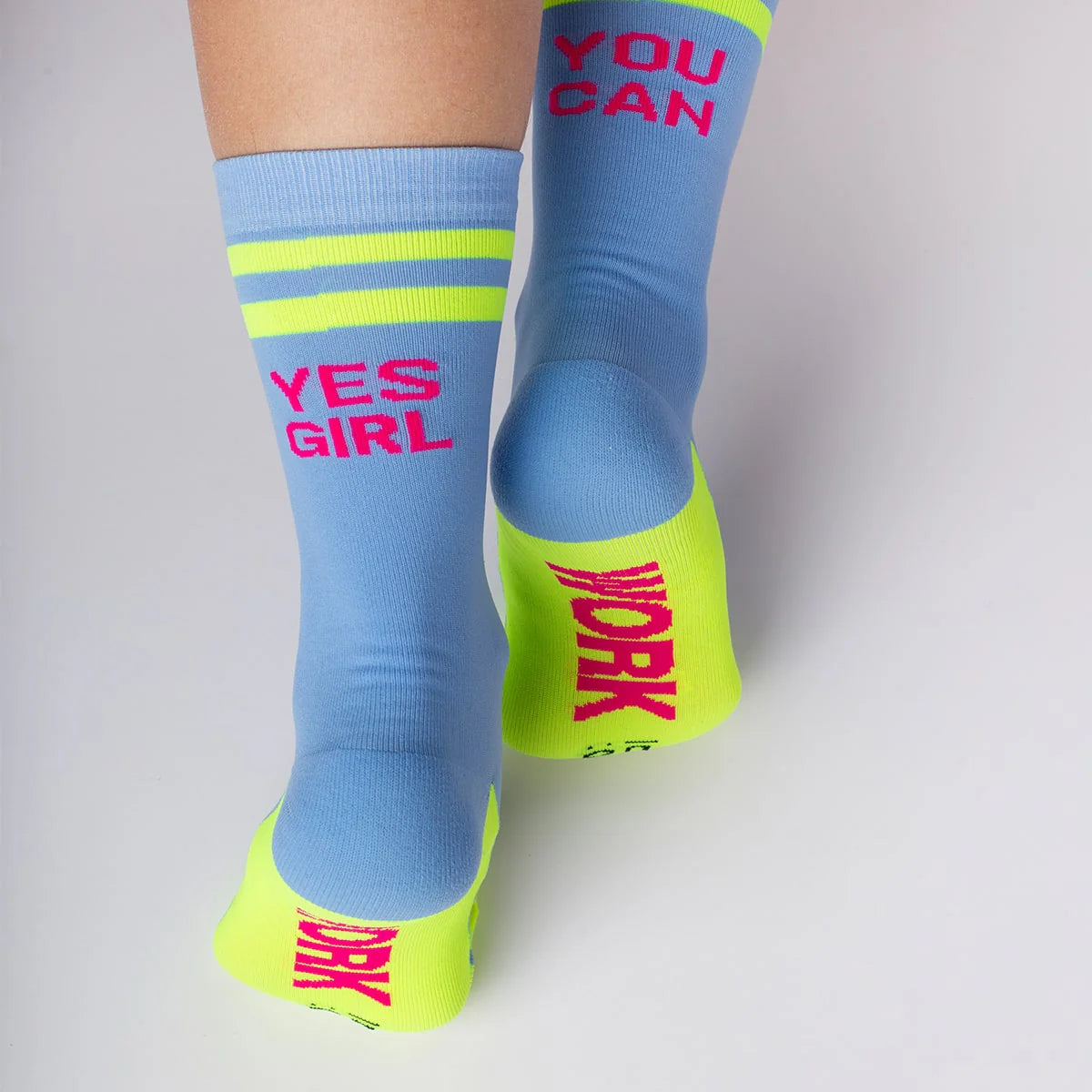 Chica con los calcetines deportivos azules con el mensaje "Calcetines para darlo todo" work en la planta y yes girl you can