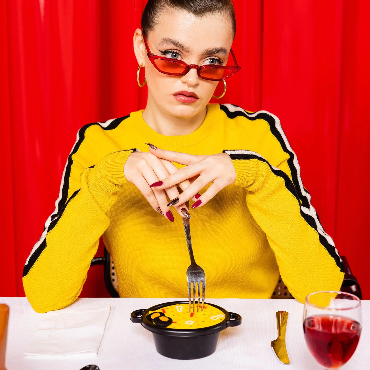modelo sentada a la mesa con un tenedor y comiendo del paellero donde se encuentran los calcetines Spanish Paella de Eat my socks