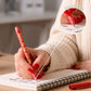 persona escribiendo en una libreta con el boli rojo de no me da la vida