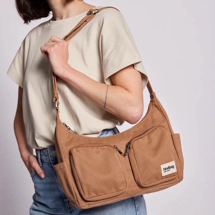 Persona lleva el bolso Emile de la marca Hindbag en canela. 