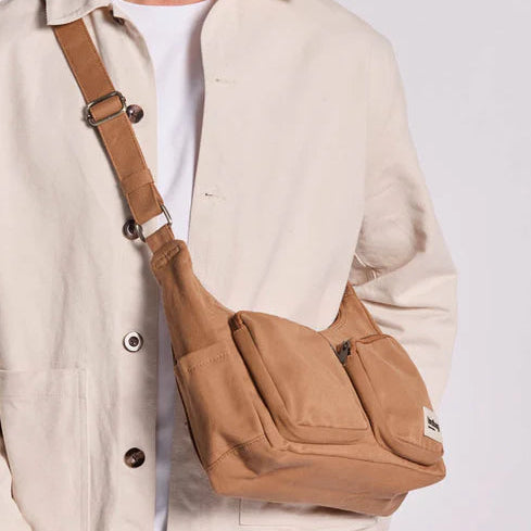 Persona lleva el bolso Emile de la marca Hindbag en canela. 