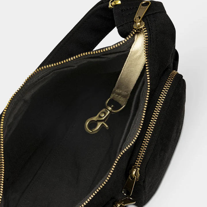 interior del bolso Emile en negro donde se ven los bolsillos y un llavero interior.