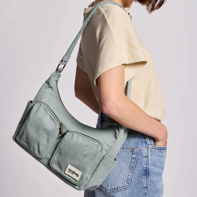 Persona lleva el bolso Emile de la marca Hindbag en salvia. 