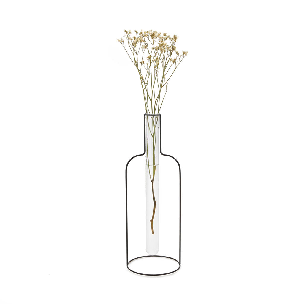 Florero con forma de silueta de botella de hierro con una probeta de cristal que contiene un tallo de flores secas