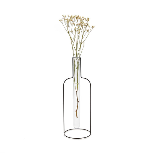 Florero con forma de silueta de botella de hierro con una probeta de cristal que contiene un tallo de flores secas