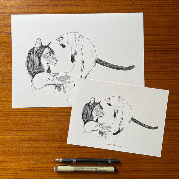 Tamaño A4 y a A5 de la print con ilustración de Laura Agustí de una chica tatuada en el brazo con cara de gato sosteniendo en el aire a un gato siamés