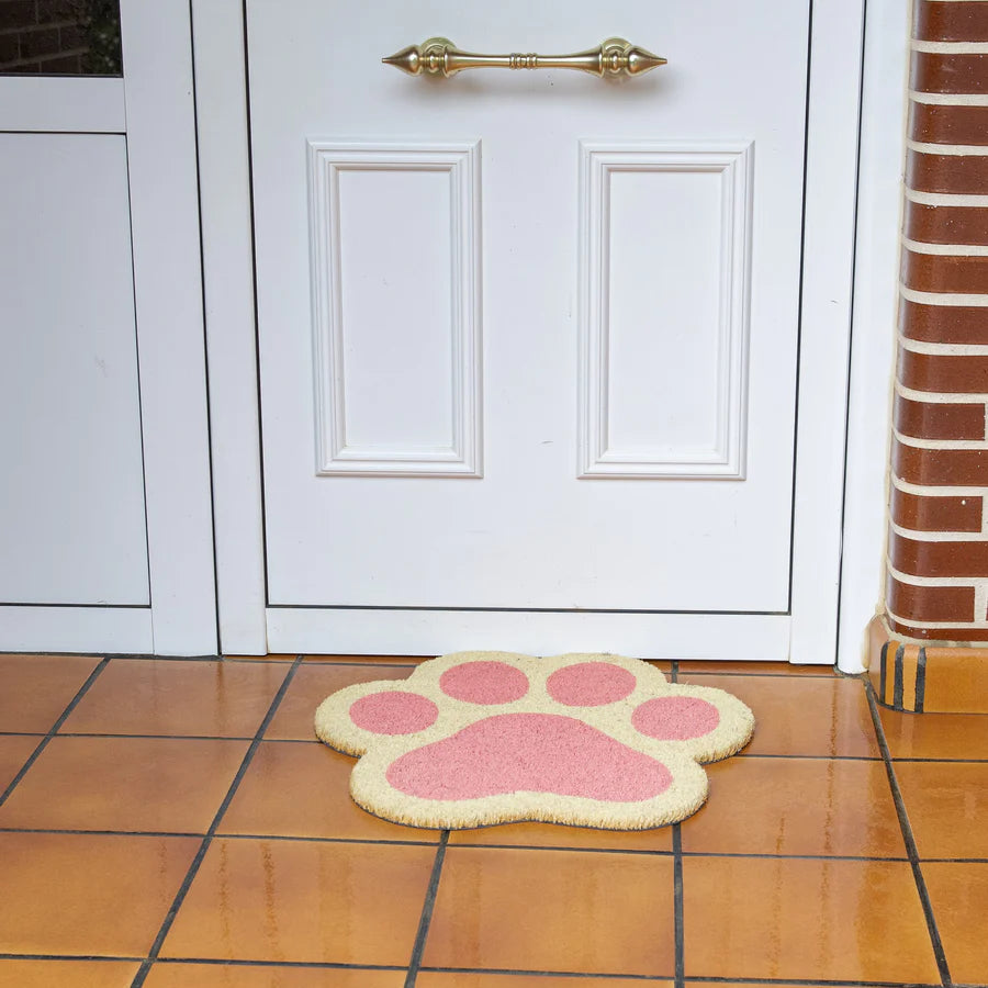 Felpudo con forma de patita de gato en rosa en la puerta de entrada de una casa