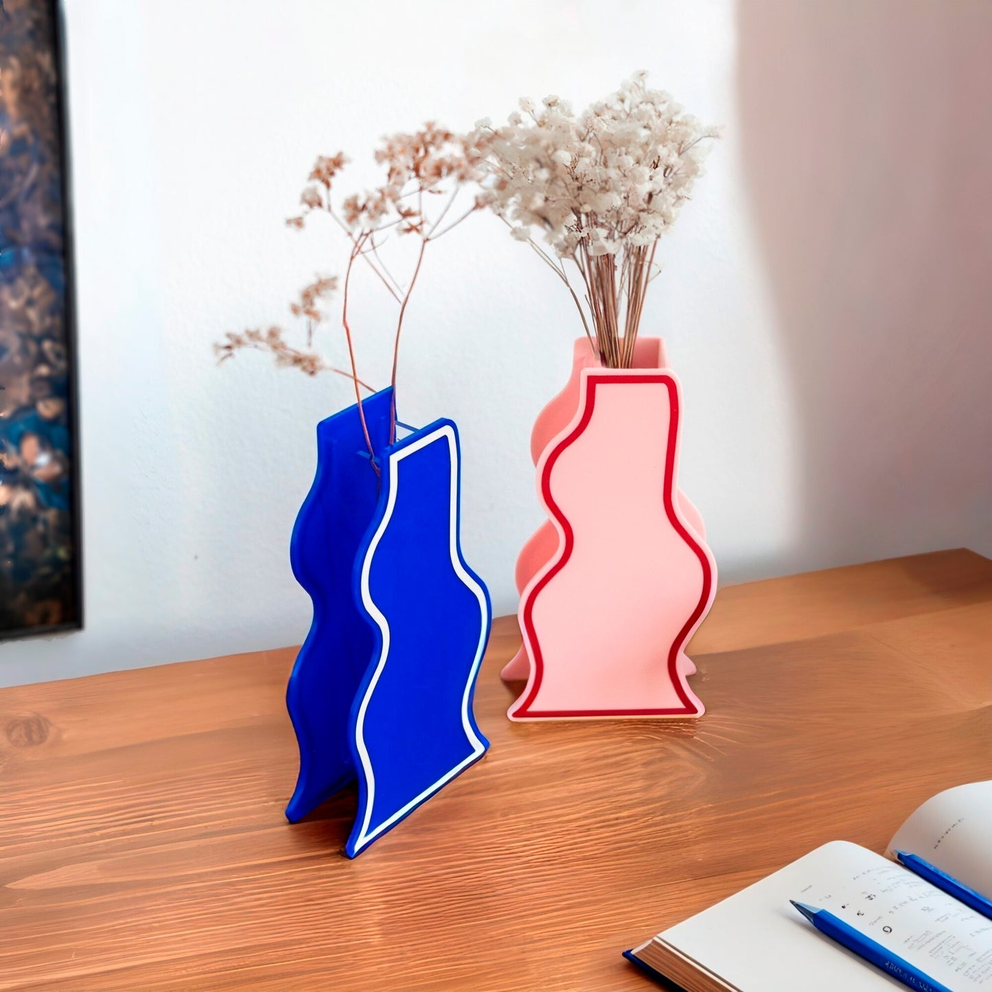 Floreros con formas abtracta en color azul klein y rosa con línea en el contorno