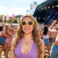 Chica en un concierto con unas gafas de sol con montura a rayas amarillas y blancas