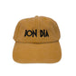 Gorra de color mostaza con las palabras "bon dia" bordadas