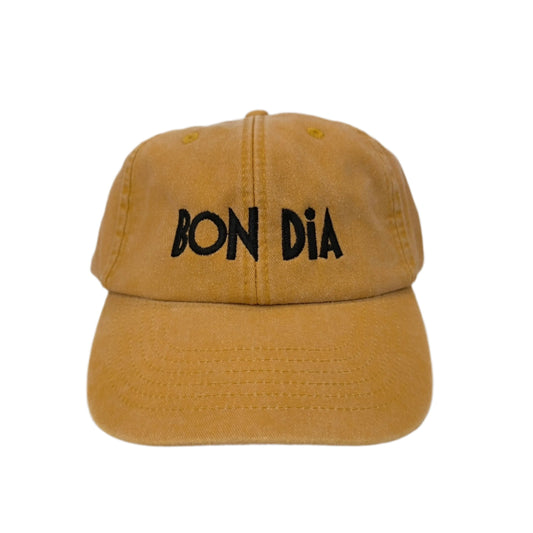 Gorra de color mostaza con las palabras "bon dia" bordadas