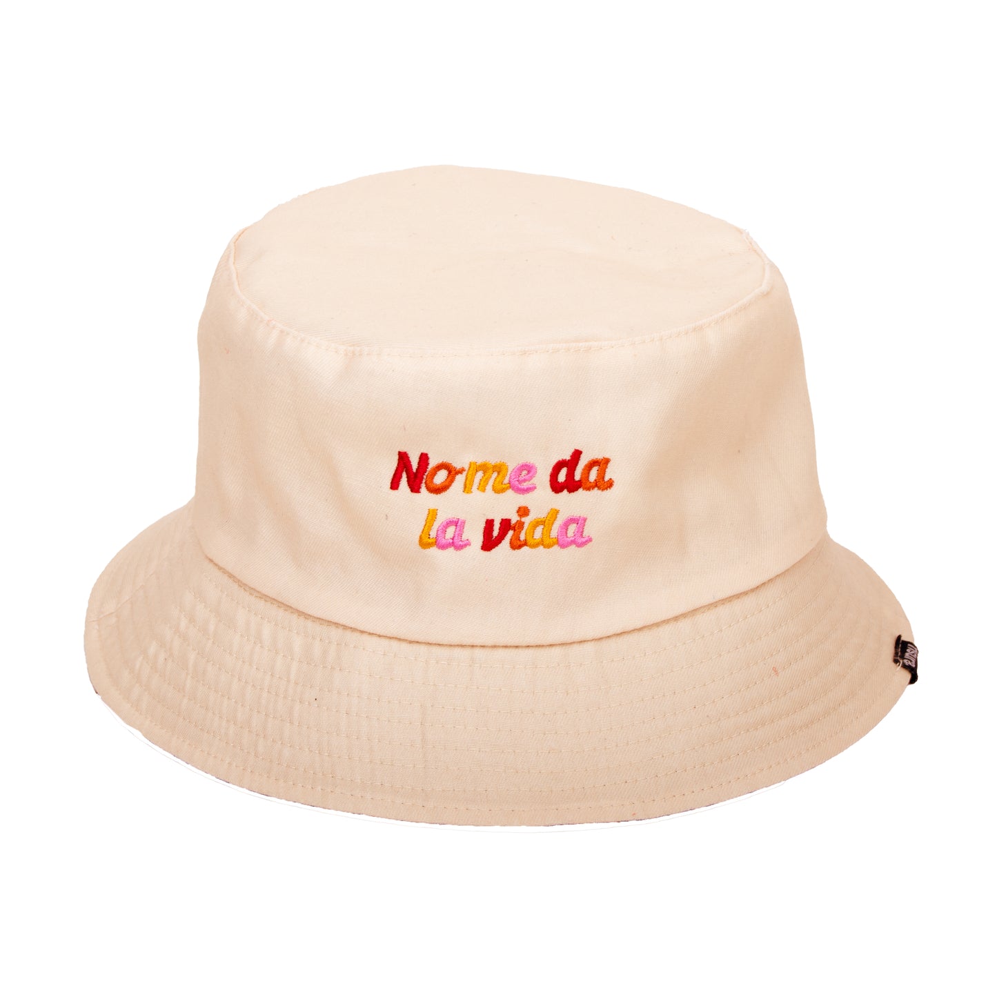 gorro de pescador de tela reversible en color beige con la frase "no me da la vida" bordada en letras de colores
