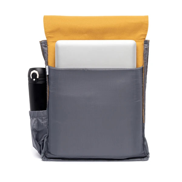 Interior de la mochila 100% reciclada en color mostaza, de tela gris con compartimentos para portátil y bolsillo lateral para botella de agua