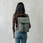 Mochila Handy mini Arles Acacia de Lefrik en verde grisáceo, llevada a la espalda para mostrar su tamaño y forma rectangular.