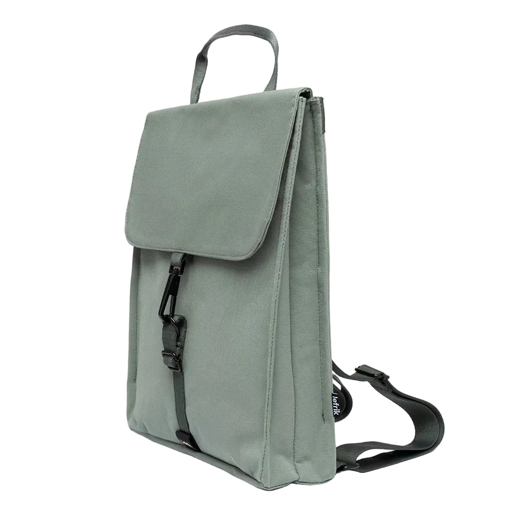 Vista en ángulo de la mochila Handy mini Arles Acacia de Lefrik en verde grisáceo, con perfil estrecho y cierre frontal ajustable.