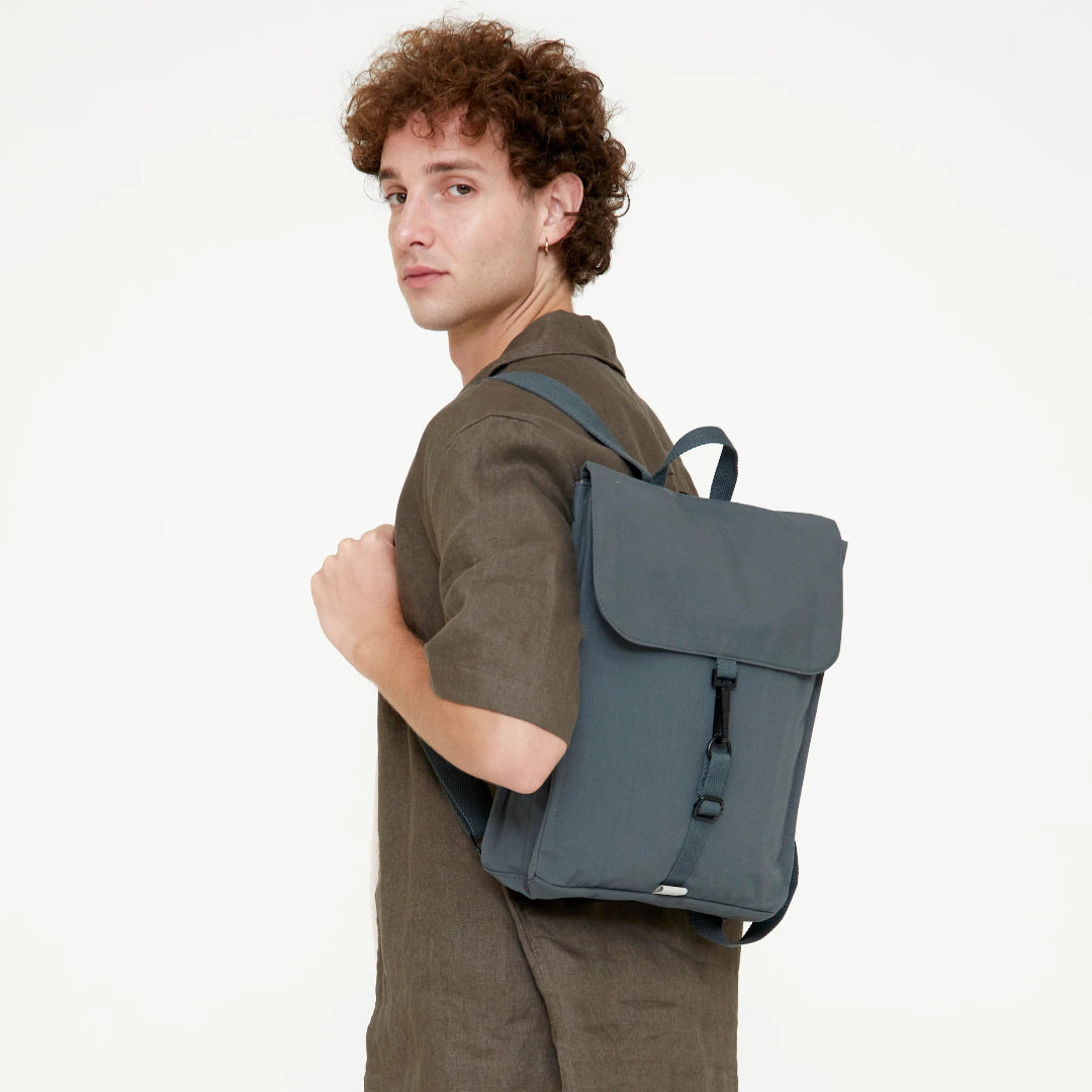 Modelo de perfil con la mochila Lefrik color gris pizarra a la espalda

