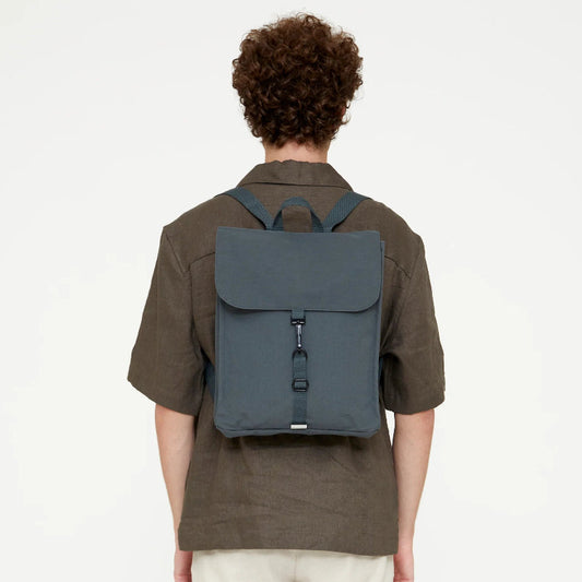 Vista trasera de modelo masculino llevando la mochila Lefrik gris pizarra a la espalda, mostrando el ajuste de las correas