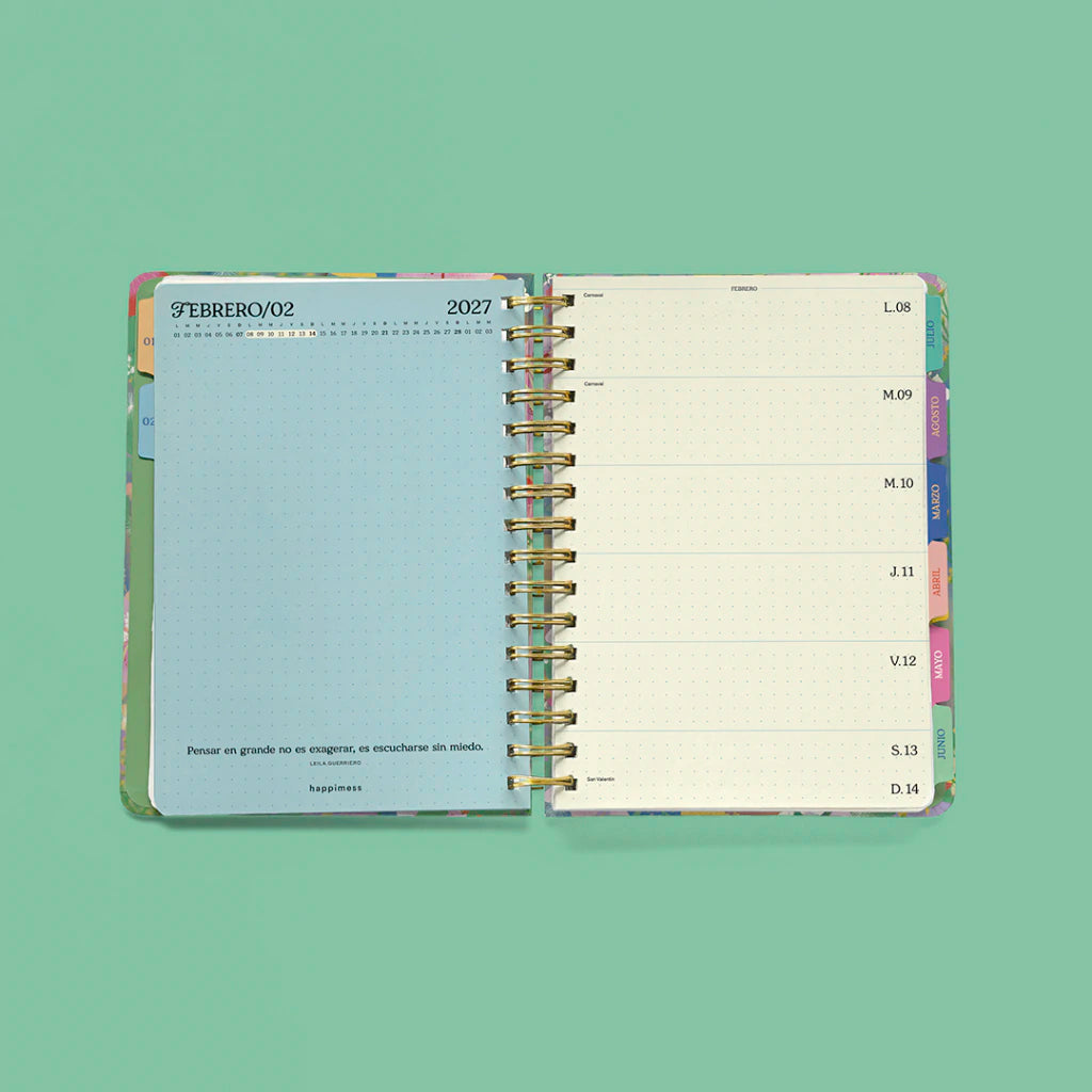 Interior agenda semanal 2027 Happimess Primavera abierta mostrando separador mensual azul de febrero con frase motivacional y página semanal horizontal con dias de lunes a domingo y pestañas de colores