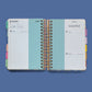 Agenda diaria 2027 Sol de mayo Happimess abierta mostrando paginas interiores con separadores de colores y diseno arcoiris