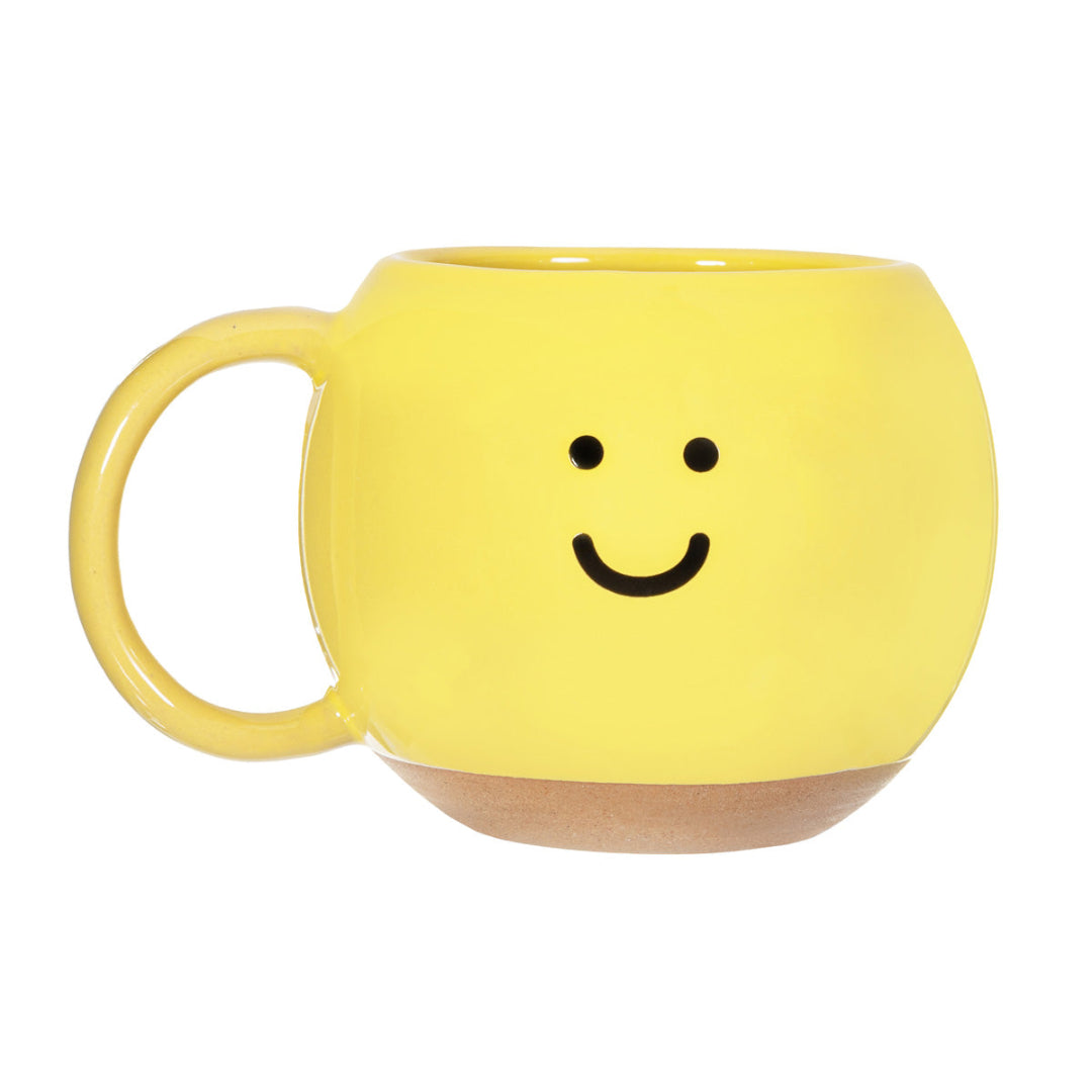 Taza amarilla con carita sonriente. 
