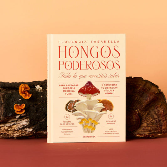Libro Hongos Poderosos de Florencia Fasanella, con todo lo que necesitas saber sobre micología, apoyado sobre un tronco