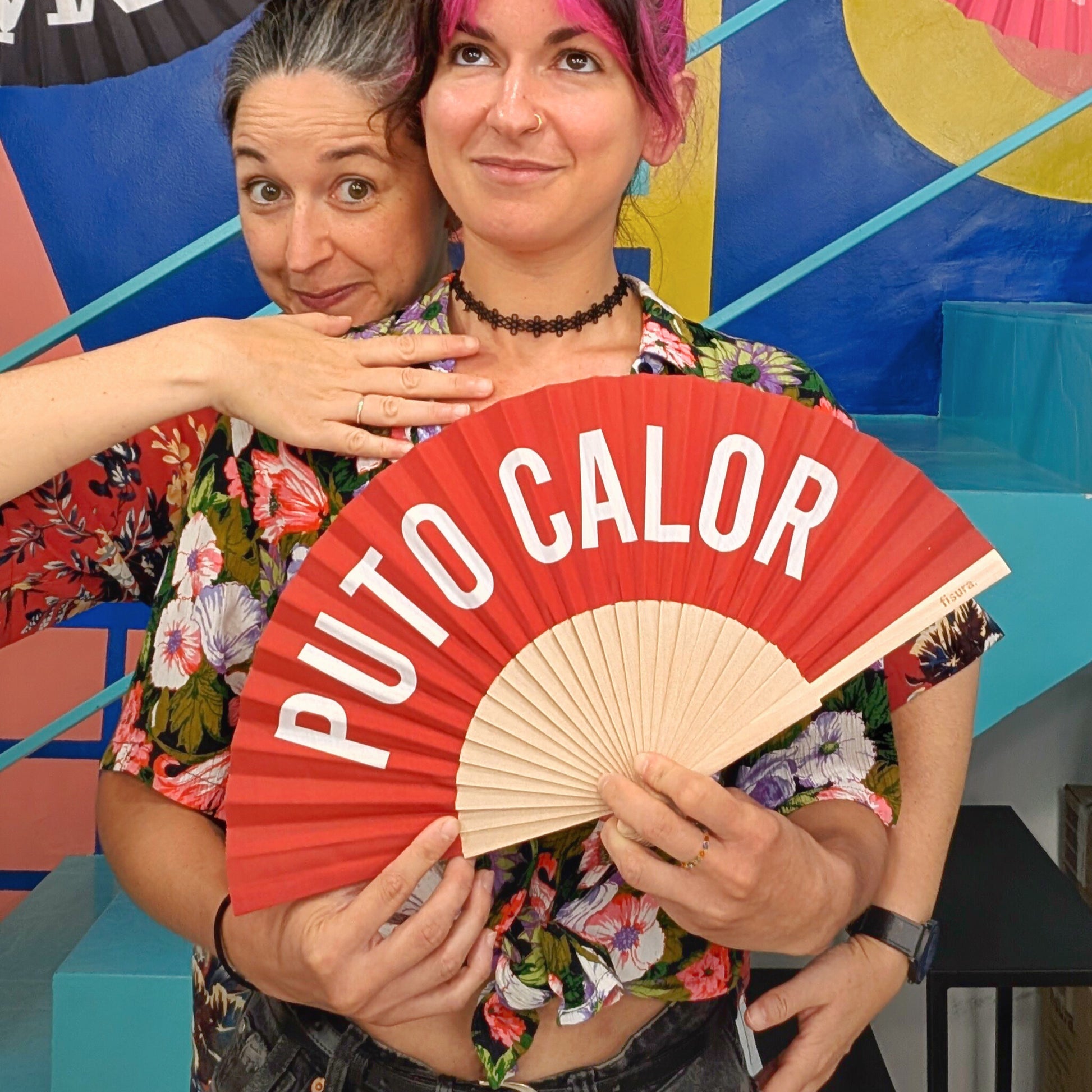 Mujer feliz con el abanico rojo de PUTO CALOR para combatir el calor