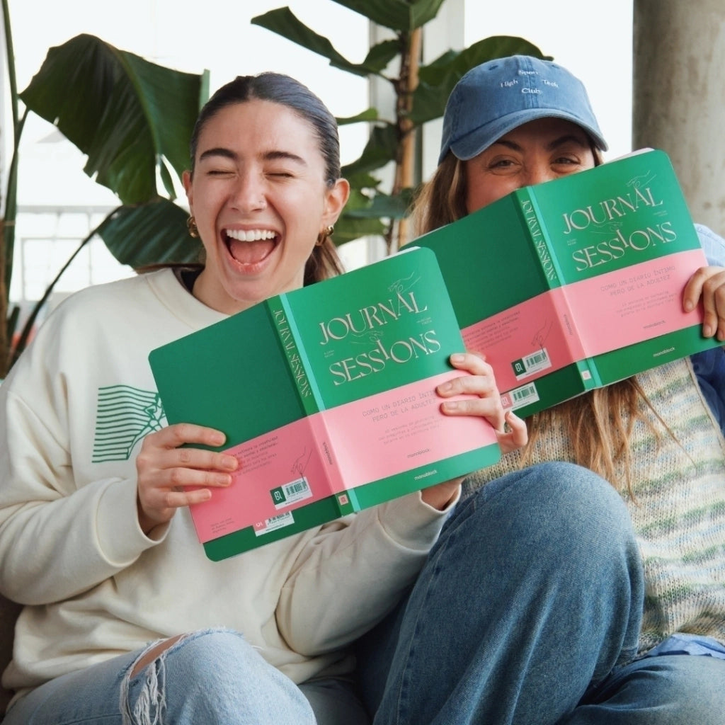 Dis chicas riéndose con el cuaderno Journal Sessions, para practicar la escritura escribiendo el diario 