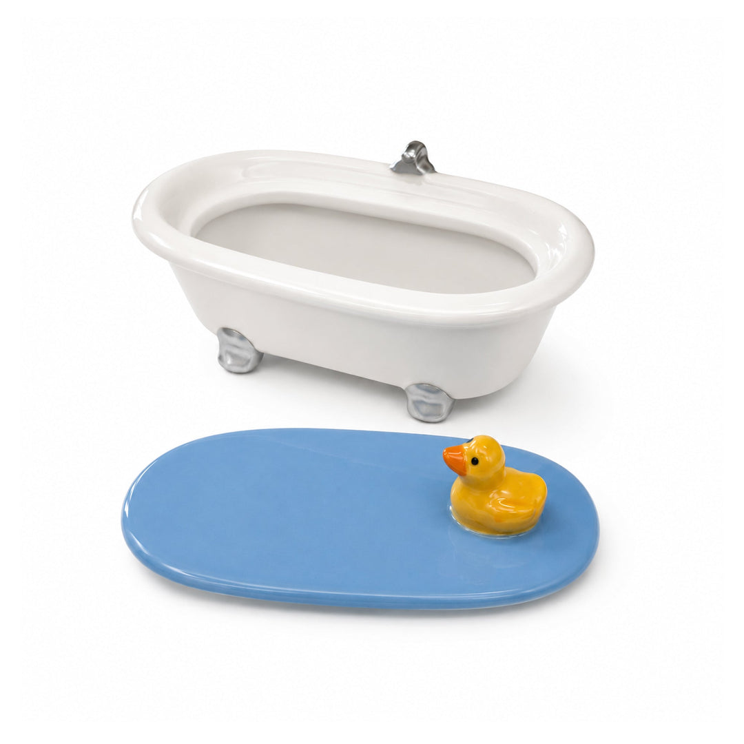 Joyero decorativo de cerámica con forma de bañera con tapa con un pato nadando en la superficie del agua destapado.