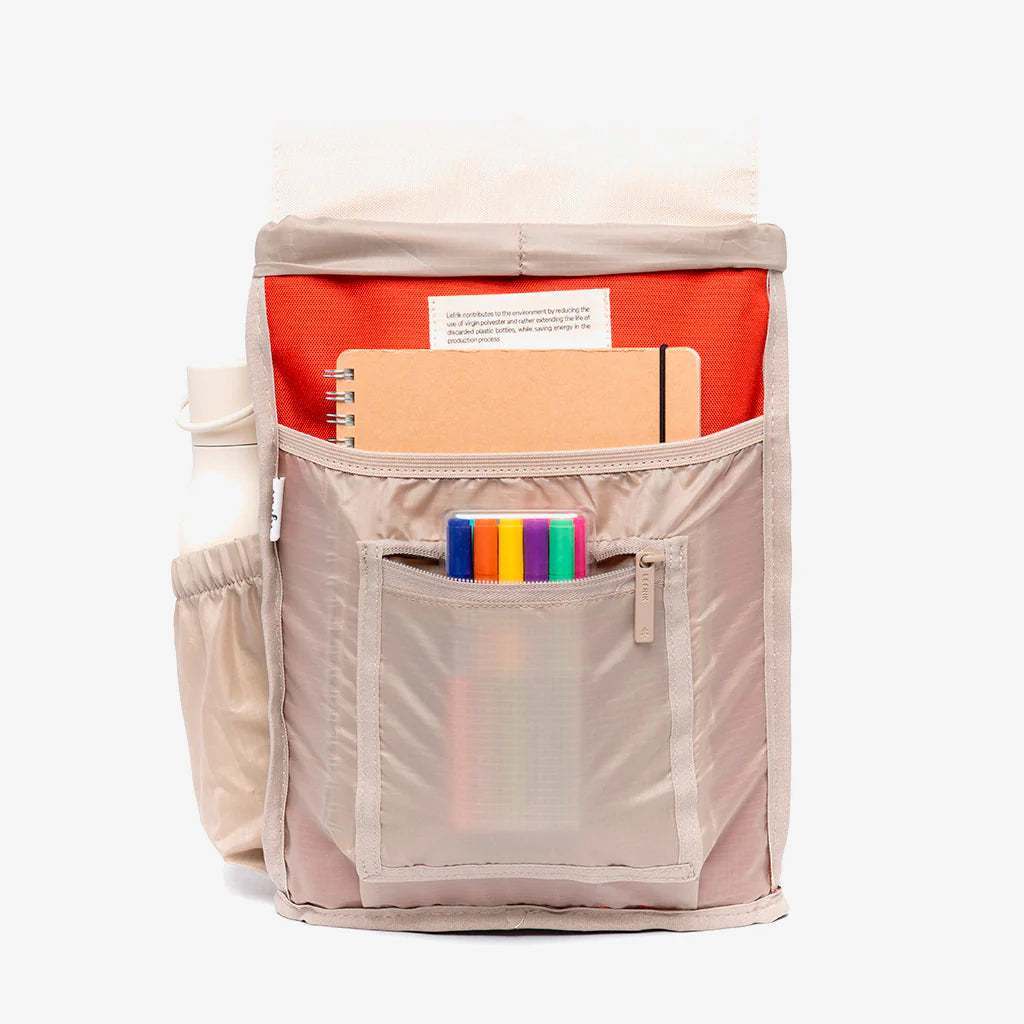 Parte interior de la mochila de lefrik del modelo scout mini con la solapa en color blanco, el cuerpo en rojo y la base en color granate con compartimentos para diferentes artículos