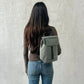 Mochila Kaut mini Arles Acacia de Lefrik en verde grisáceo, llevada a la espalda para mostrar su tamaño compacto.