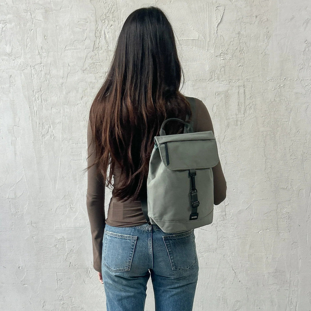 Mochila Kaut mini Arles Acacia de Lefrik en verde grisáceo, llevada a la espalda para mostrar su tamaño compacto.