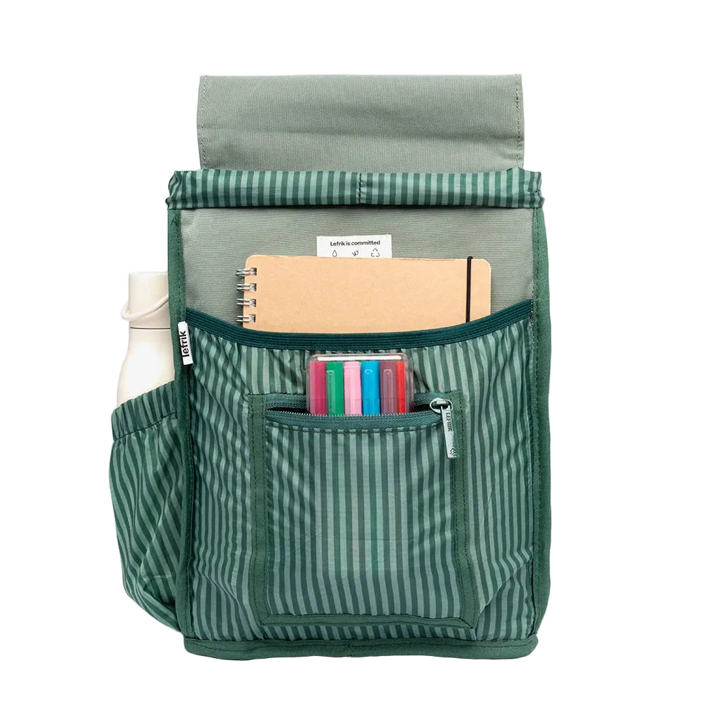 Interior de la mochila Kaut mini Arles Acacia de Lefrik, con forro de rayas verdes y compartimentos con una libreta, rotuladores y una botella.