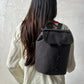 Mochila Kaut mini Arles Cemento de Lefrik en gris oscuro, llevada a la espalda para mostrar su tamaño compacto.