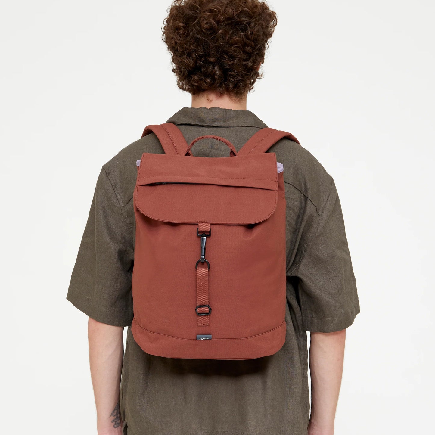 chico de espaldas llevando puesta la mochila de lefrik en modelo scout en color teja bronze