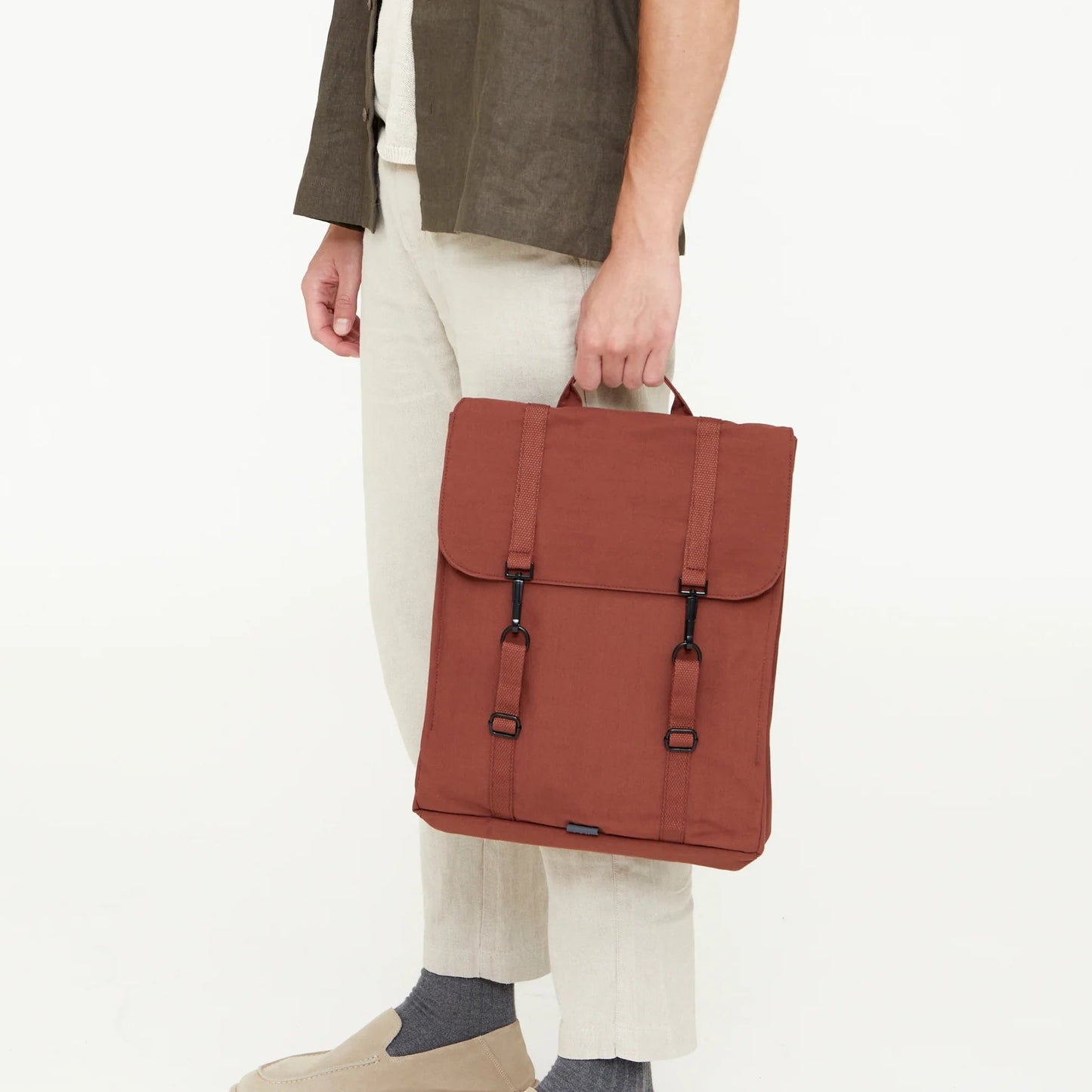 modelo posando con la mochila handy bronze de lefrik en color ladrillo