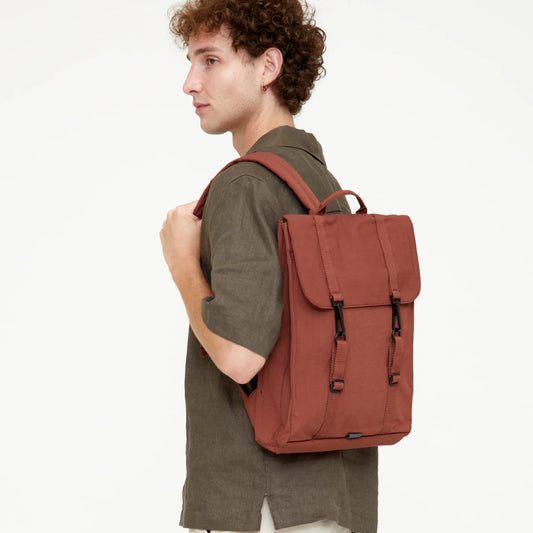 chico posando con la mochila handy de color bronze marrón rojizo puesta sobre un hombro