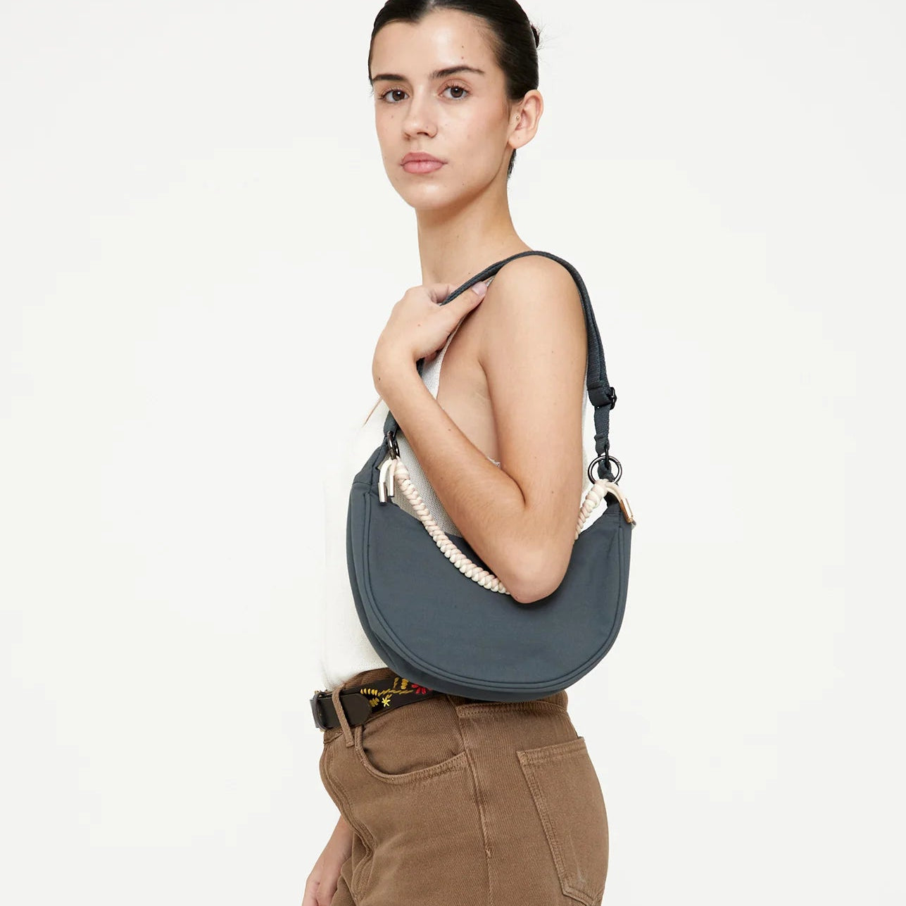 modelo posando con el bolso lua de lefrik azul hoja de laurel llevándolo como un bolso de un hombro