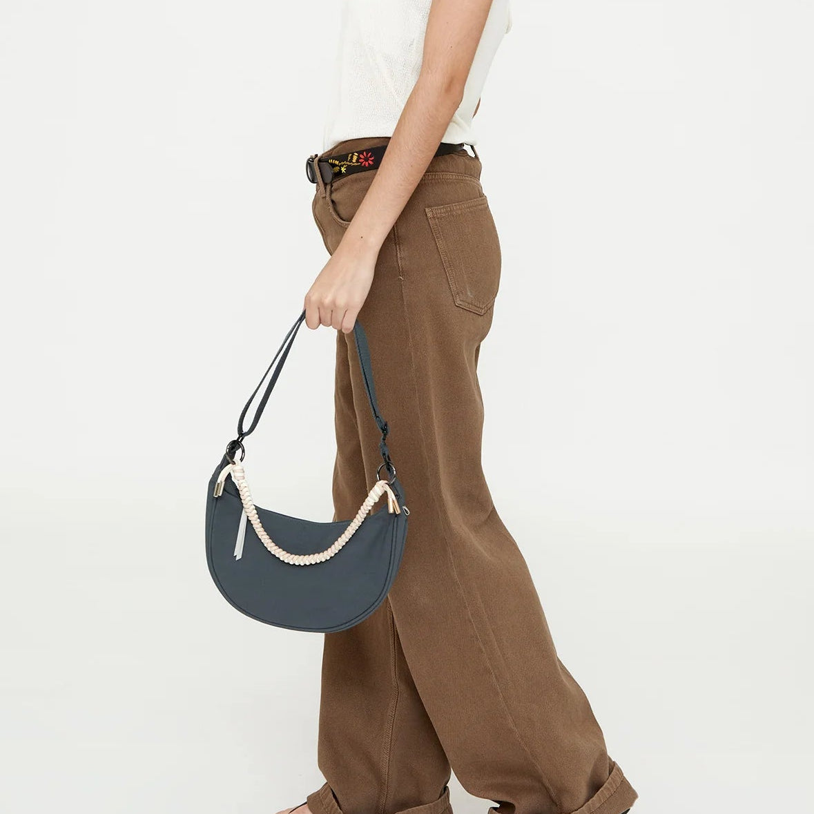 modelo con el bolso lua hoja de laurel cogiéndolo como bolso de mano de las asas