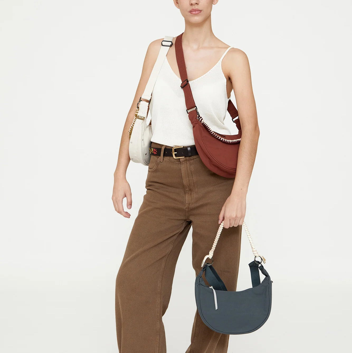 modelo posando con los bolsos de lefrik del modelo lua en colores hoja de laurel, bronze y con puntos