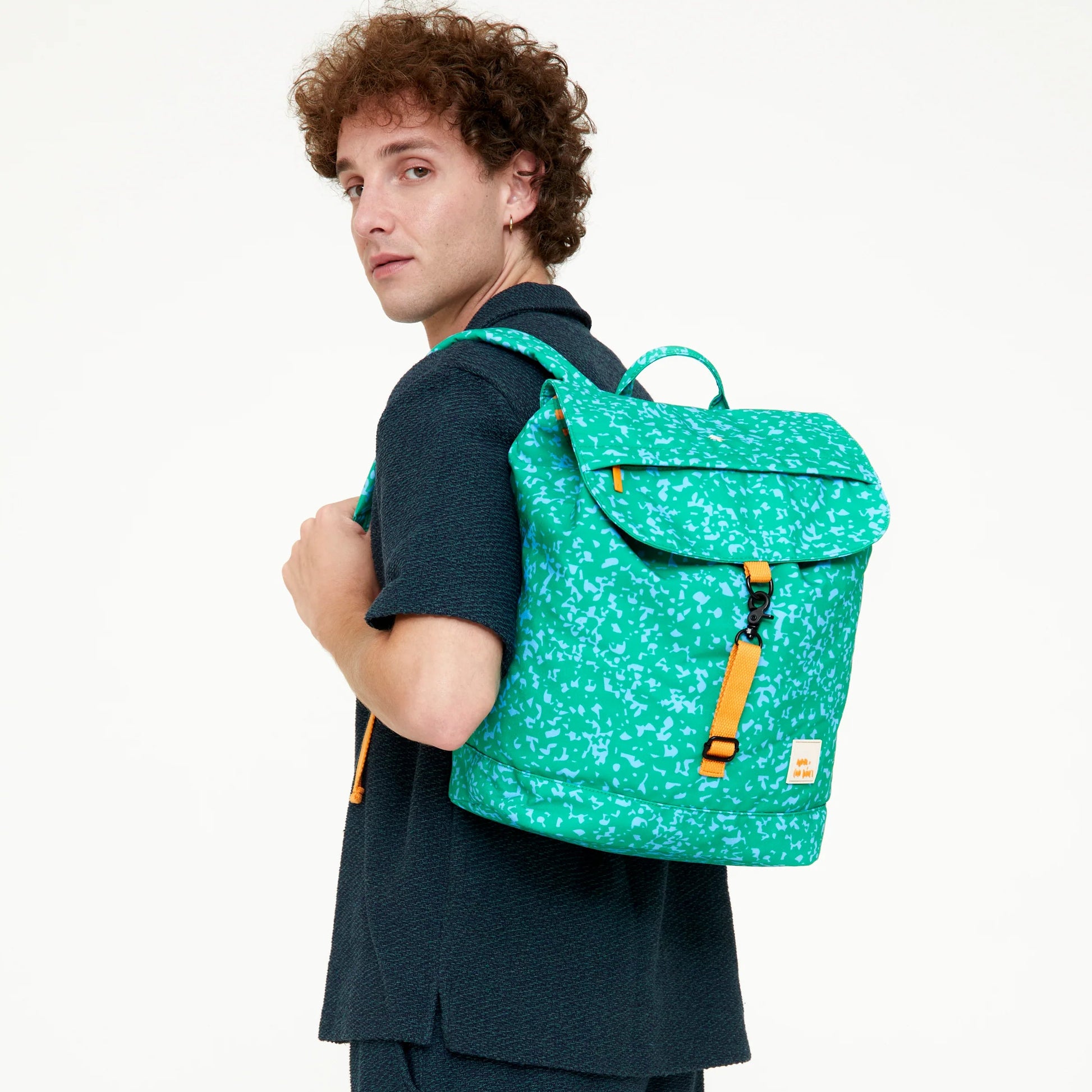 modelo de espaldas con la mochila del modelo scout coco davez en color azul y amarillo, posada sobre uno de los hombros